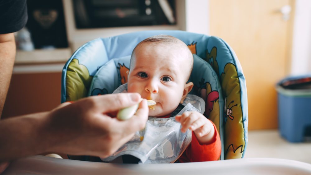 Little baby eating yummy food from spoon
