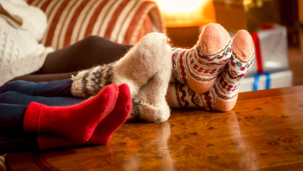 Winter Safety Mini – Guide, At Home, Closeup conceptual shot of family warming feet at fireplace